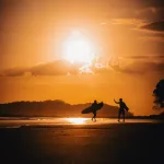 Zwei Surfer am Strand bei Sonnenuntergang im Surferparadies Panama.