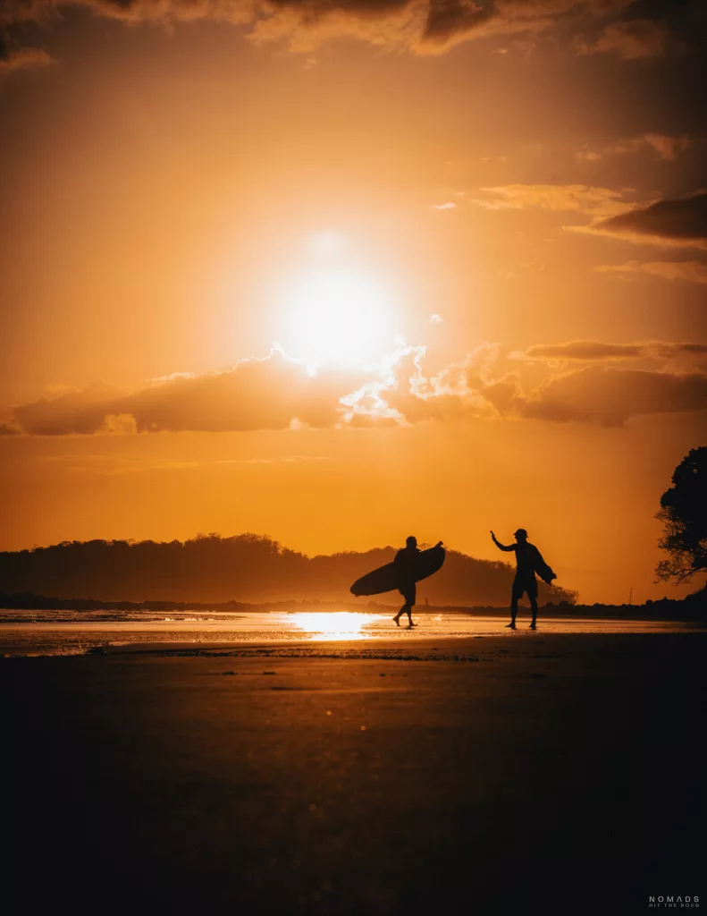 Zwei begeisterte Surfer geben sich am atemberaubenden Strand von Panama ein High Five. Unvergessliche Surfabenteuer in Panama erleben.