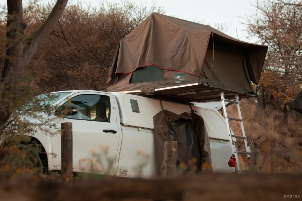 Weißer Pickup mit aufgestelltem Dachzelt auf einem Campingplatz am Lake Oanob in Namibia.