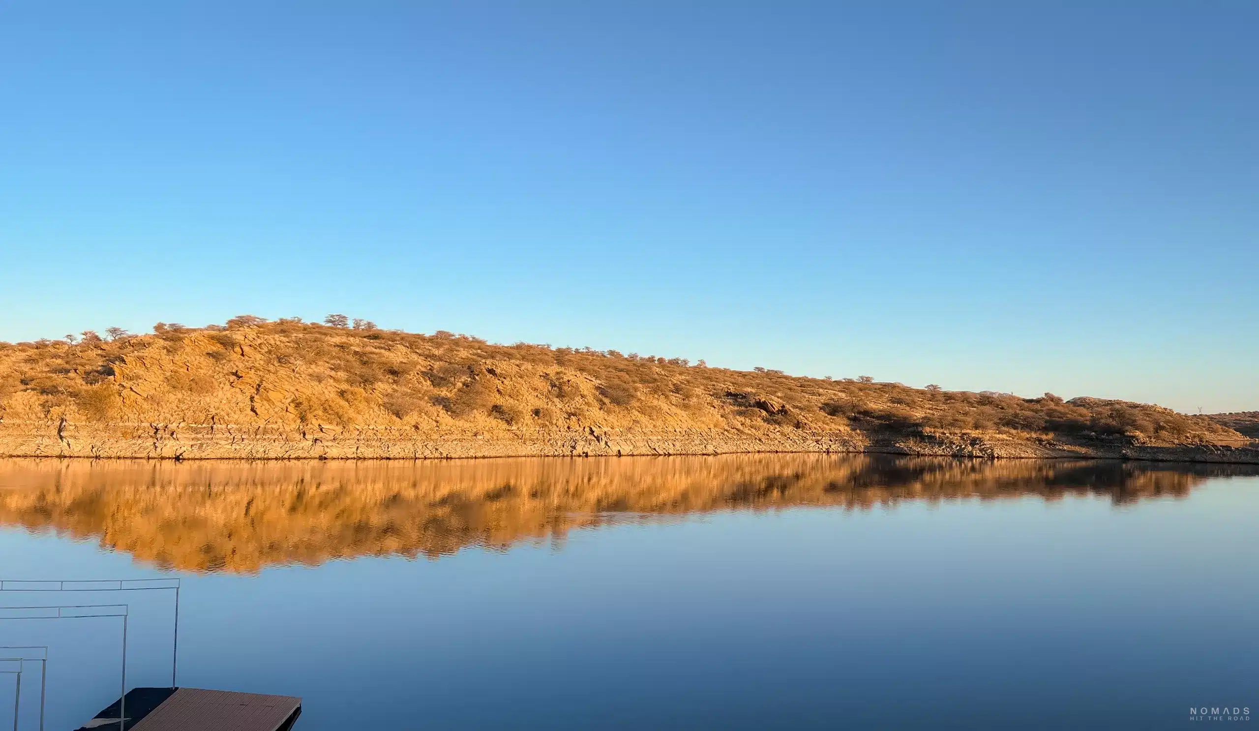 Blick auf See mit Felsformation, die sich im Wasser spiegelt