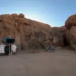 Mietwagen mit Dachzelt vor Felsen auf einer Campsite in Spitzkoppe