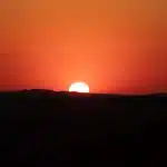 Sonnenuntergang mit rotem Himmel und Sonnenball in Spitzkoppe
