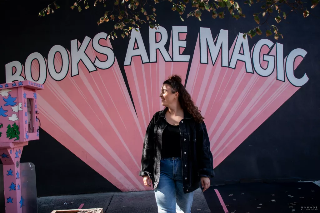 Schriftzug in weiß und pink Books are magic in New York City mit Frau im Vordergrund