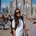 Frau in weißem Shirt auf Brooklyn Bridge in New York City
