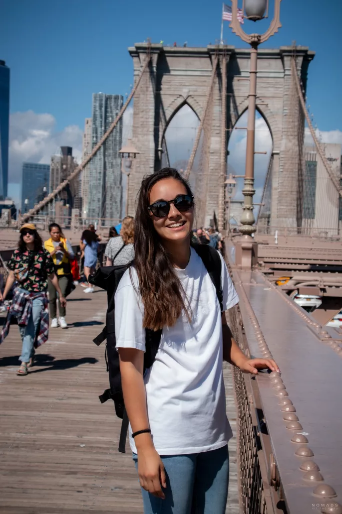 Frau in weißem Shirt auf Brooklyn Bridge in New York City