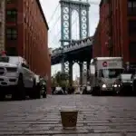 Dumbo Manhattan Bridge View Aussichtspunkt mit einem Kaffeebecher von Arabica auf der Straße im Vordergrund