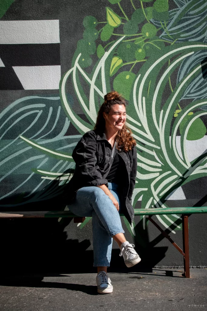 Frau auf Bank sitzend vor einer Graffiti Wand in New York City