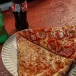 Vielfältigkeit der verschiedenen Essens-Kulturen in New York City: Zwei Stücke Pizza von Joe’s Pizza