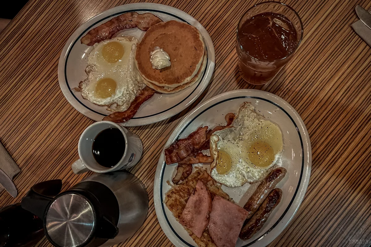 Frühstück iHop mit Eiern, Bacon, Pancakes, Würstchen und Getränken