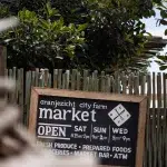 Schild mit Öffnungszeiten des Oranjezicht City Farm Market