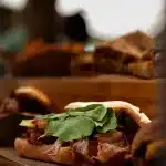 Belegtes Baguette mit Bacon auf einem Holzbrett auf dem Oranjezicht Market