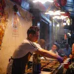 Koch am Straßenrand bei der Arbeit in Chinatown in Bangkok
