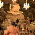 Mönche beim Beten vor Buddhastatue im Wat Arun Bangkok