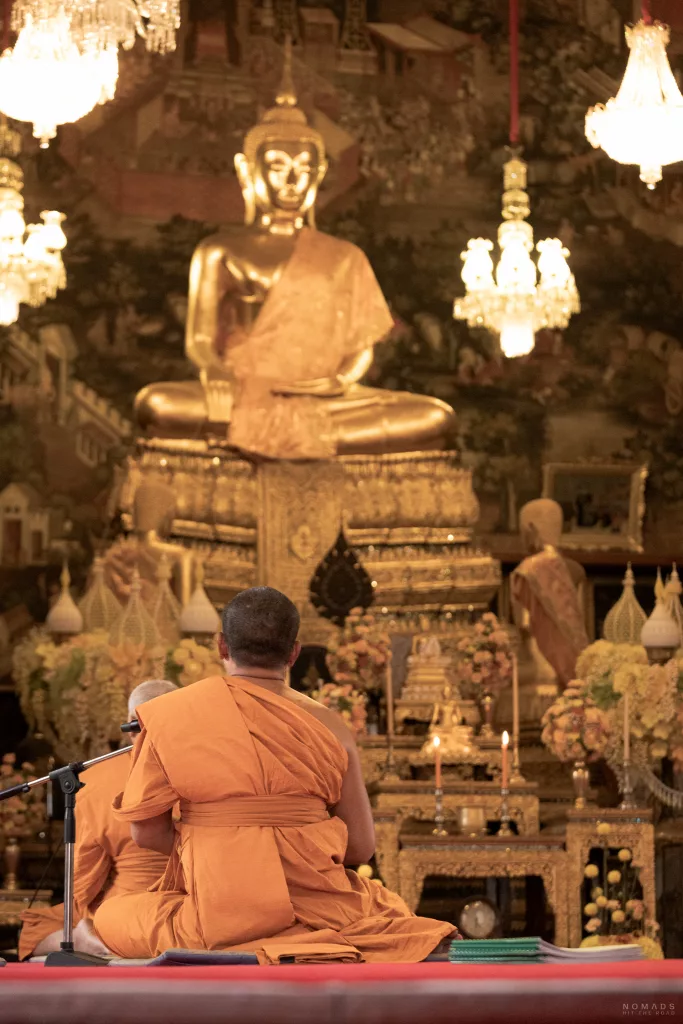 Mönche beim Beten vor Buddhastatue im Wat Arun Bangkok