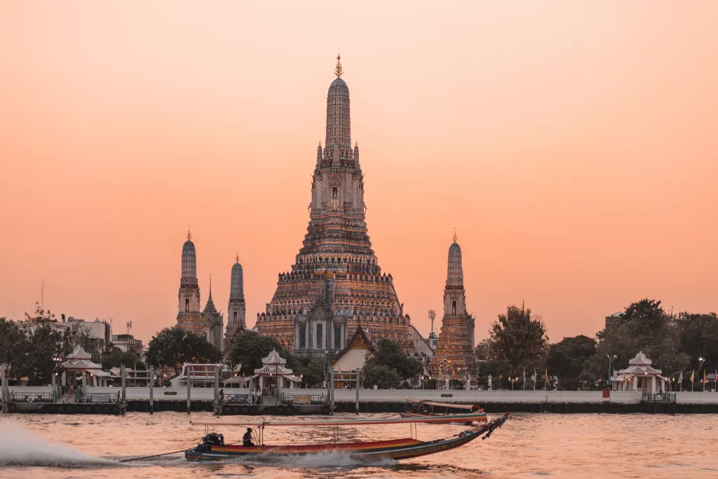 Wat Arun Bangkok bei Sonnenuntergang mit Boot auf dem Chao Phraya