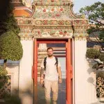 Mann geht durch Tür in buddhistischer Tempelanlage Wat Pho in Bangkok