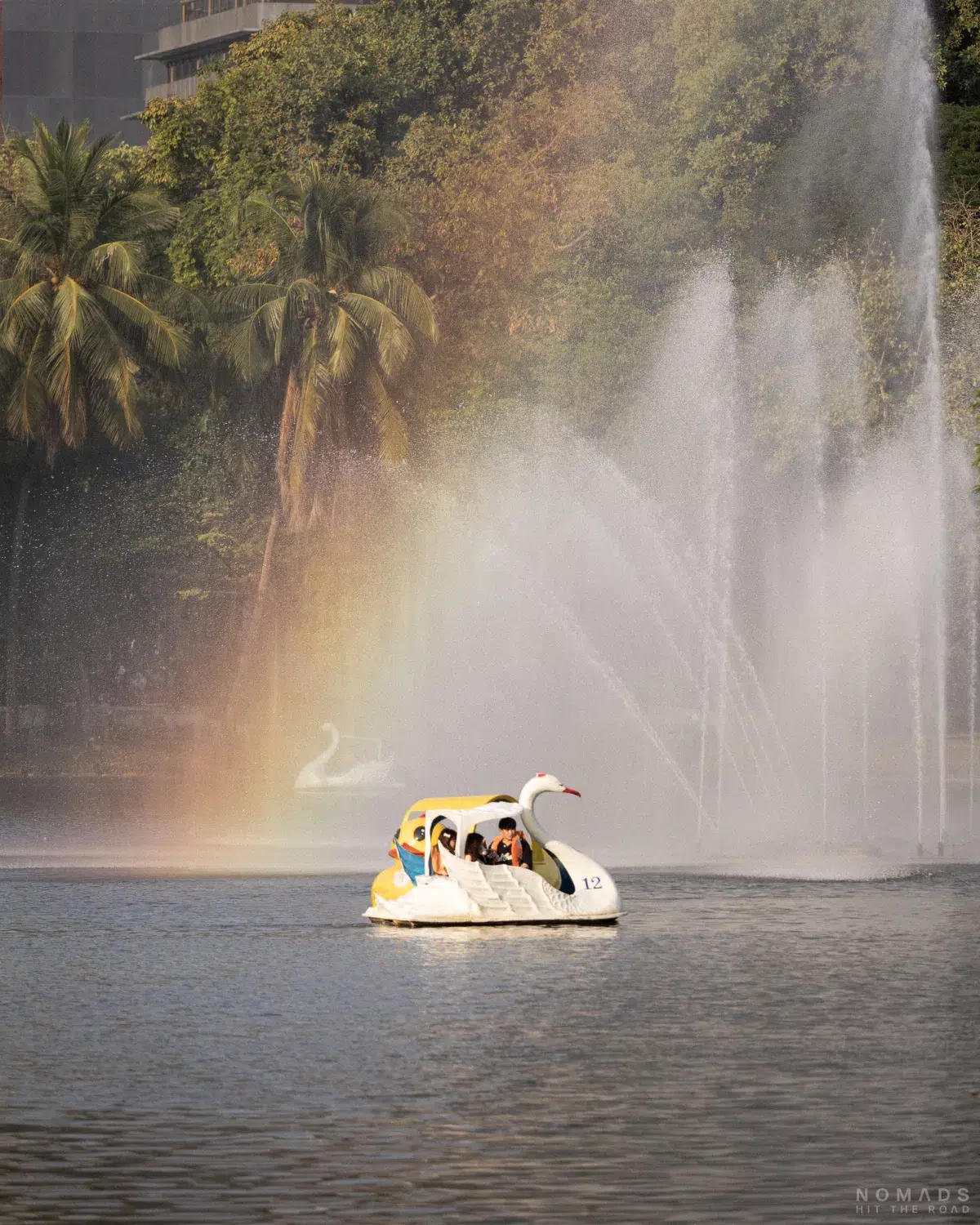 Tretboot auf dem künstlich angelegten See im Lumphini Park mit einer Wasserfontäne im Hintergrund