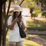 Frau mit Handy in der Hand im Lumphini Park