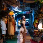 Frau auf dem Chatuchak Nachtmarkt in einer Gassen mit Shops für Kleidung