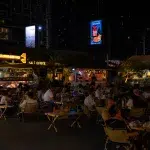 Sitzplätze und Essensstände auf dem Jodd Fairs Rama 9 Nachtmarkt in Bangkok