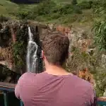 Mann von hinten, der auf den Wasserfall der Berlin Falls an der Panorama Route blickt