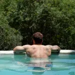 Mann im Pool in der Leopard's Lair Lodge am Greater Kurger