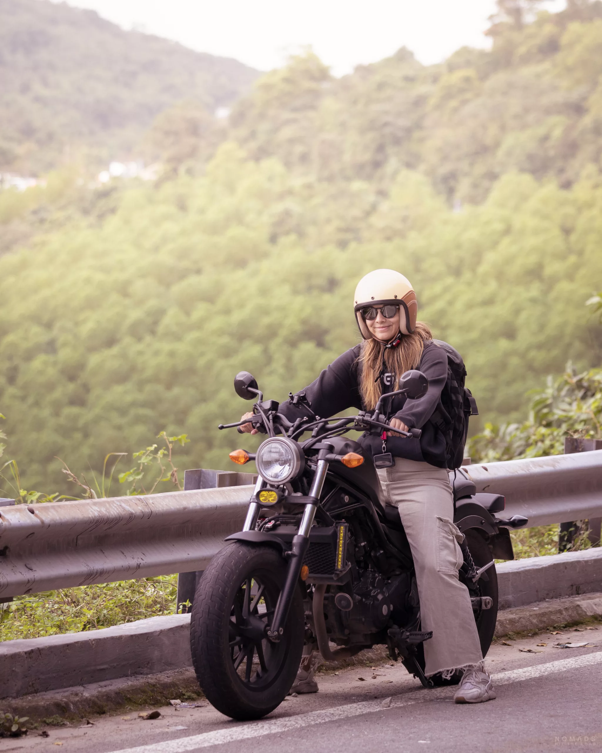 Frau sitzt lachend auf ihrem Motorrad. Vietnam, Hai Van Pass