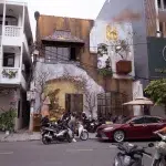 Café von außen mit Rollern und Autos im Vordergrund