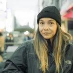 Frau mit schwarzer Wintermütze und Jacke in Tokio