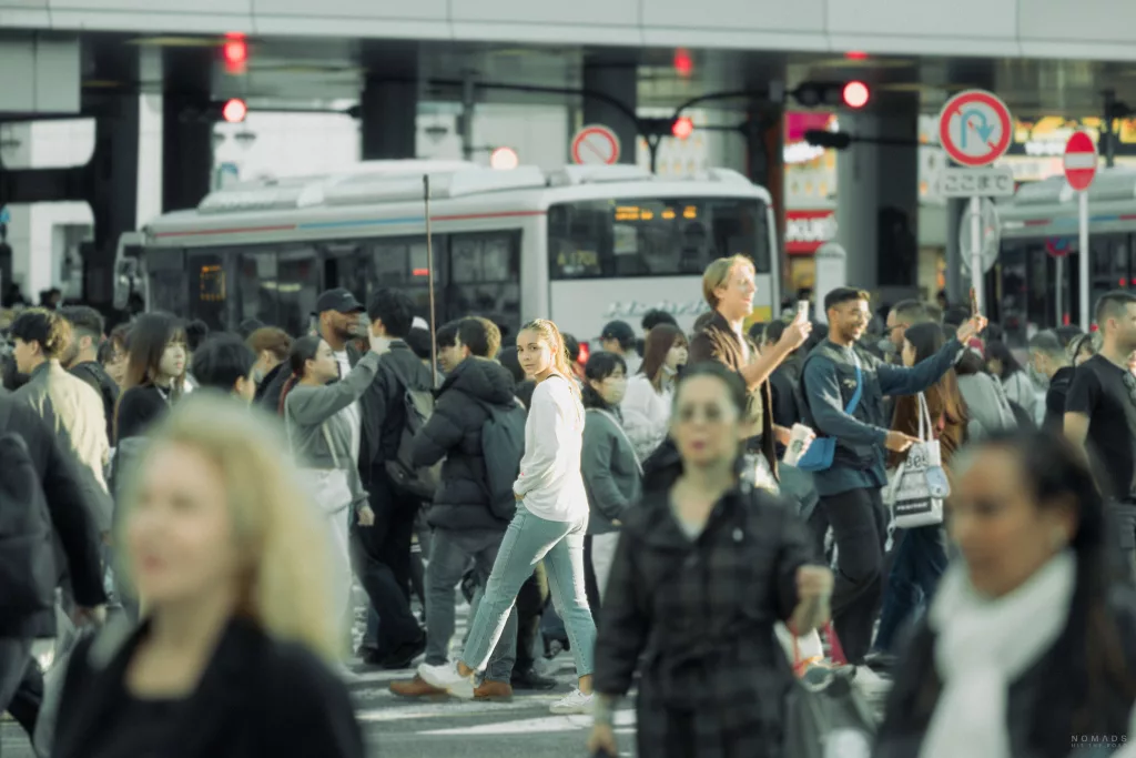 Frau auf der Shibuya Crossing inmitten von Menschen