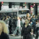 Frau auf der Shibuya Crossing inmitten von Menschen