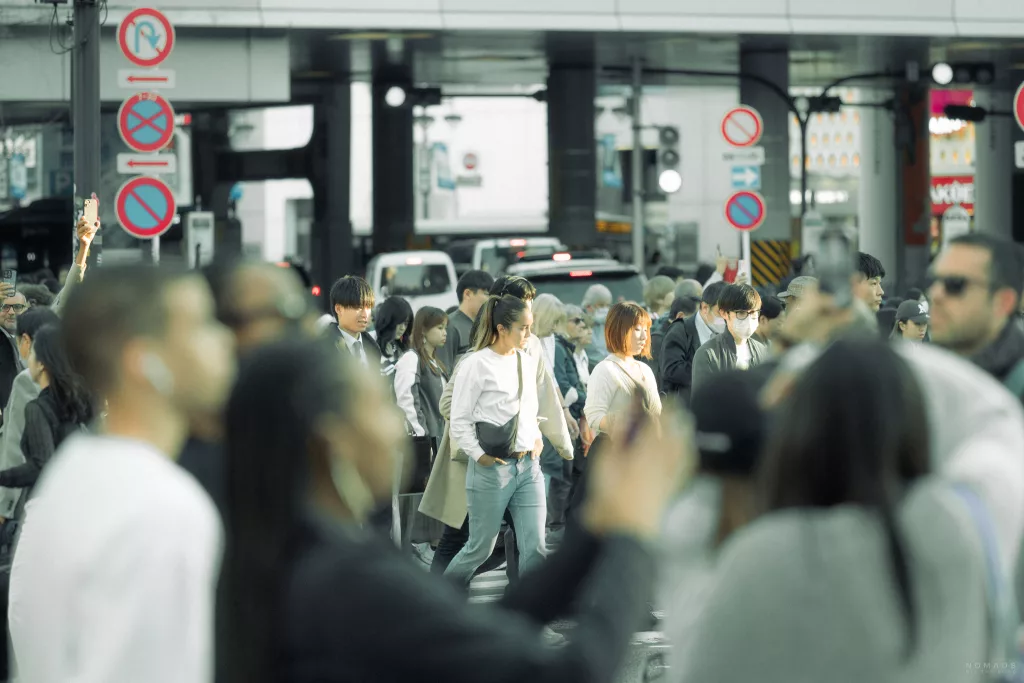 Frau zwischen Masse an Menschen auf der Shibuya Crossing in Tokio