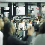 Frau zwischen Masse an Menschen auf der Shibuya Crossing in Tokio