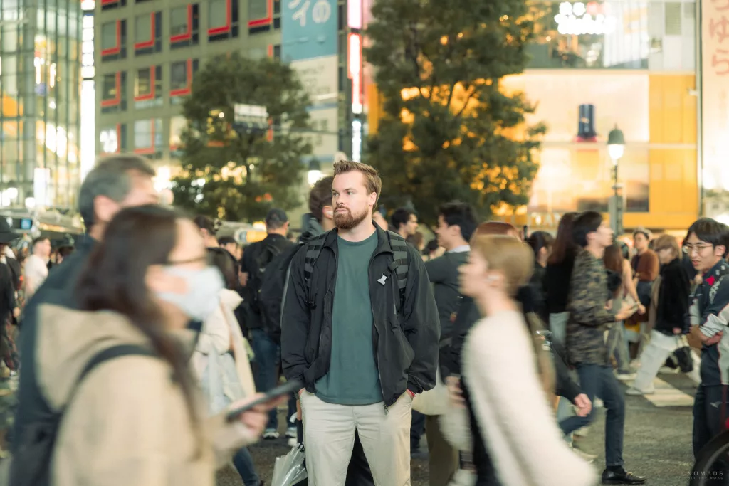 Mann auf der Shibuya Crossing inmitten von Menschen
