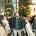 Mann auf der Shibuya Crossing inmitten von Menschen