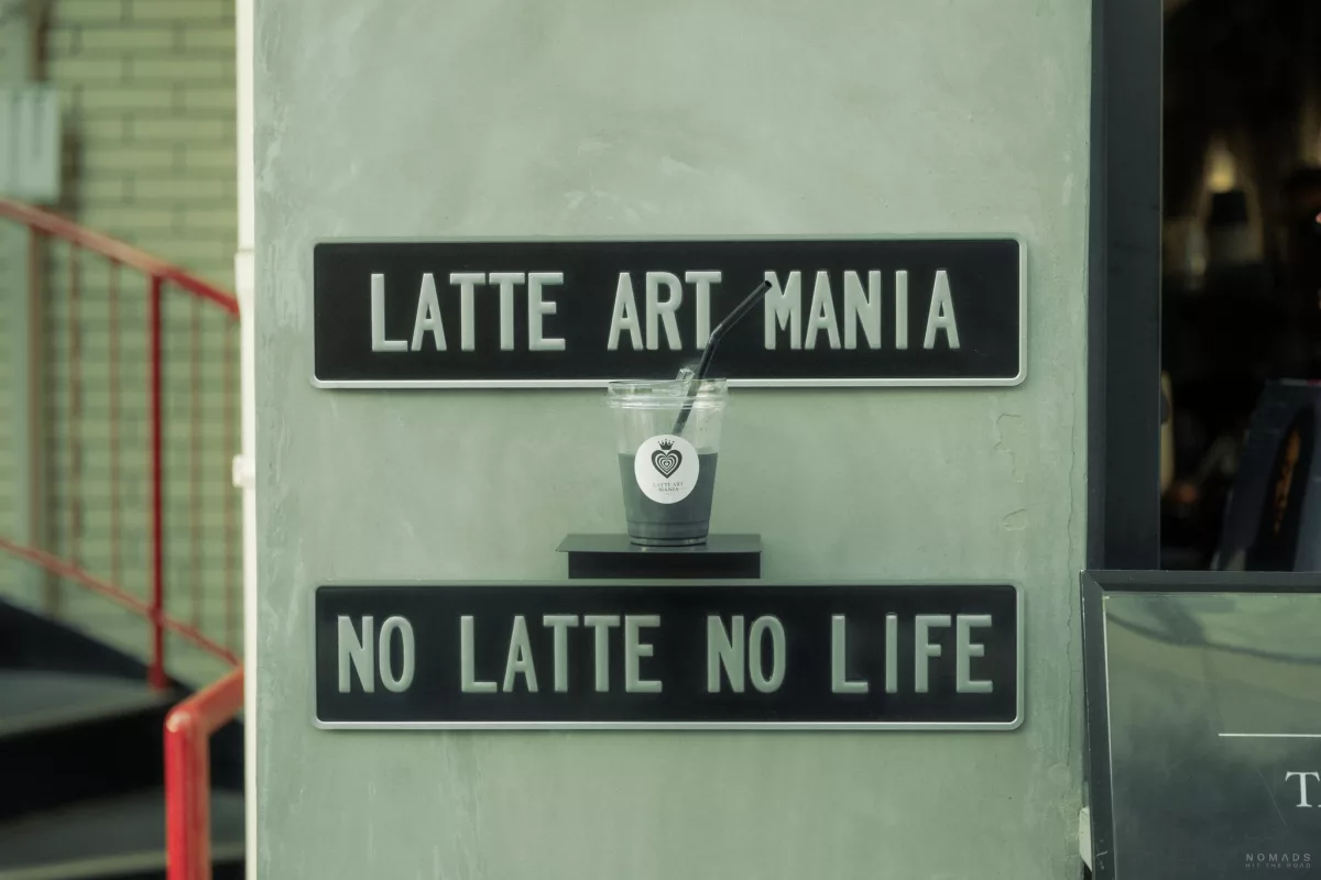 Schild und Kaffee vom Café Latte Art