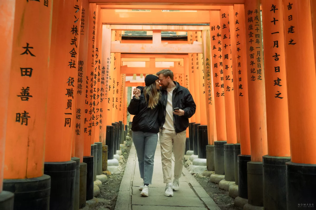 Pärchen läuft durch die orangenen Tore des Fushimi-Inari-Taisha Schreins in Kyoto