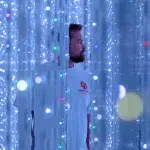 Mann zwischen Lichterketten im teamLab Planets Tokyo