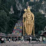 Goldene Statue des Gott des Krieges Murugan und bunte Treppen am Eingang der Batu Caves