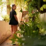 Junge Frau läuft über den mit Pflanzen bewachsenen Flur des Coffee Apartments