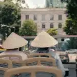 Besucher der Hop On Hop Off Tour durch Saigon mit traditionellen vietnamesischen Hüten
