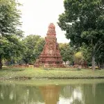 Blick auf einen Chedi hinter einem Teich mit Spiegelung im