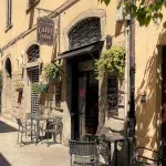 Eingang mit Tischen und Stühlen draußen vom Caffee di Famosi