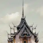 Detailansicht des kunstvollen Sanphet Prasat Palast in Ancient City, Thailand, mit einem hoch aufragenden, kunstvoll verzierten Dach.