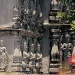 Detailaufnahme der kunstvoll geschnitzten Figuren an einer Grabstätte in Ancient City, die traditionelle thailändische Architektur zeigt.