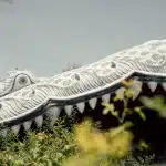 Nahaufnahme des Kopfes einer riesigen weißen Drachenfigur in Ancient City, Thailand, mit markanten Zähnen und Details.