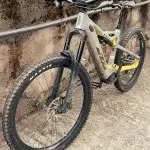 E-Mountainbike mit pinken Helm lehnt an einer Mauer nach einer Mountainbike-Tour, bereit für die nächste Fahrt.