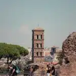 Glockenturm zwischen Mauerresten und Touristen