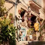 Einladender Laden in Valldemossa, dekoriert mit Strohhüten, Pflanzen und traditionellen mallorquinischen Souvenirs an einer sandfarbenen Steinfassade.