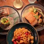 Moderne Gerichte in Albanien – Lachs, Quinoa und Pasta, serviert in einem Restaurant.